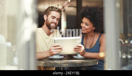 Youve got to check this out...a young couple using a digital tablet in a cafe. Stock Photo