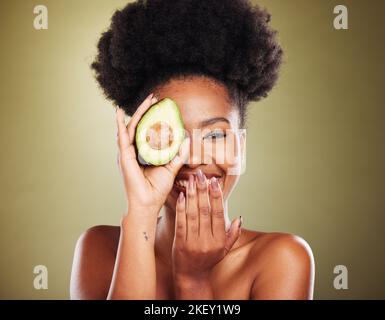 Black woman, laughing or avocado skincare on green studio background for healthcare diet, dermatology wellness or nutrition. Portrait, smile or happy Stock Photo