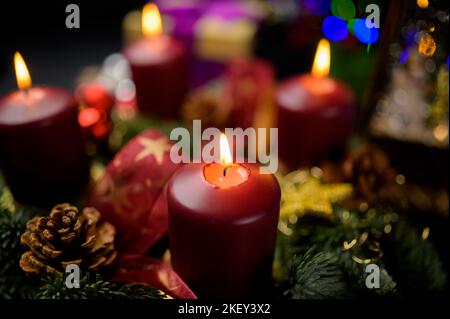 Shallow focus advent wreath with four lit candles and pine cones Stock Photo