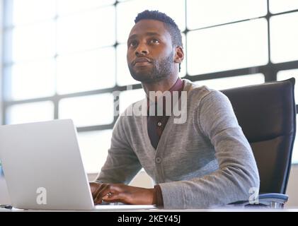 Searching online for another lucrative business opportunity. a thoughtful young businessman using a laptop in an office. Stock Photo