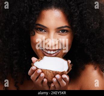 Beauty, portrait and woman holding coconut for organic skincare, bodycare and glowing skin. African american female, body care and skin care with Stock Photo