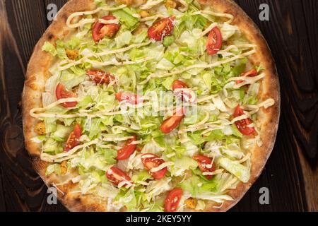 Pizza Caesar with chicken on a wooden background, top view Stock Photo