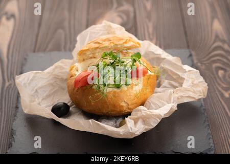 Bread bowl stuffed with mushrooms, shrimps, cheese and bolognese sauce for lunch. Julienne in a bun Stock Photo