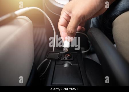 Charging smartphone battery with usb charger in the car. Stock Photo