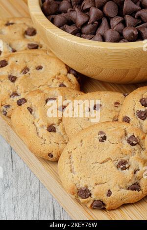Close up of Chocolate Chips and delicious chocolate chip cookies on wooden background Stock Photo