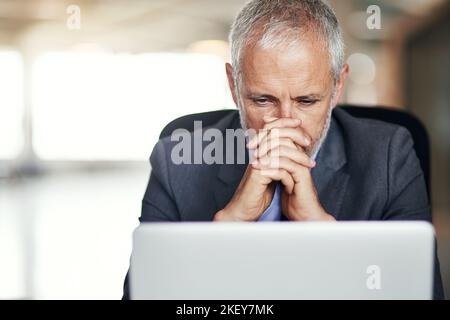 Having the worst day at work. a mature businessman looking stressed while working in his office. Stock Photo