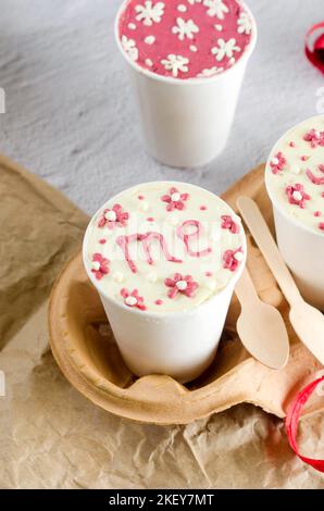 homemade mini cake in white disposable coffee cups, new confectionery trend. Paper cups with cakey  are in a box, fashionable dessert Stock Photo