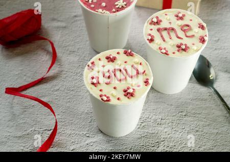 homemade mini cake in white disposable coffee cups, new confectionery trend. Paper cups with cakey  are in a box, fashionable dessert Stock Photo