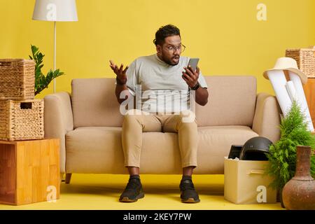 Amazed emotional man in glasses reading text message or notification on smartphone Stock Photo