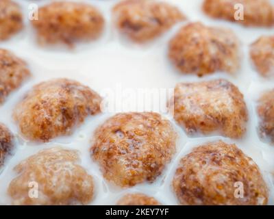 Swollen corn balls in milk close-up. Selective focus. Healthy breakfast of corn flakes and milk. Stock Photo