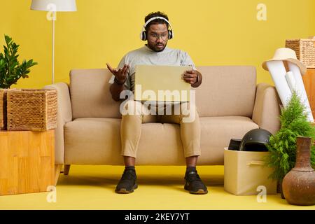 Man wearing headphones when video calling his friend or colleagues Stock Photo