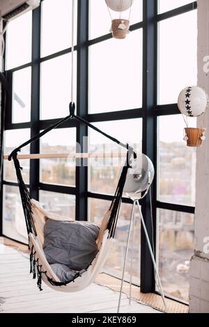 Swing hammock indoors near a large panoramic window Stock Photo