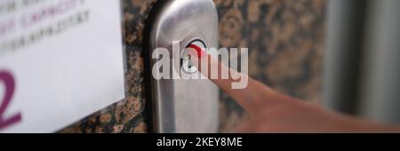 Female finger with red manicure pressing elevator button closeup Stock Photo
