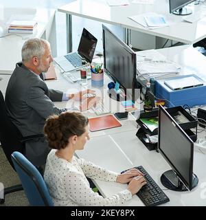 Hard at work in the office. colleagues working on their computers while sitting in an office. Stock Photo