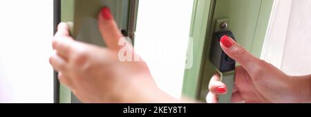 Female hands pressing button lock and opening glass door closeup Stock Photo