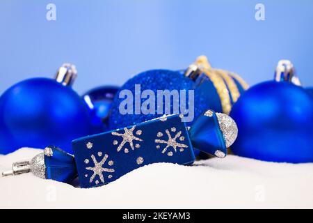 Blue Christmas balls, candy on snow with blurred background. Christmas, New Year. Copy space Stock Photo