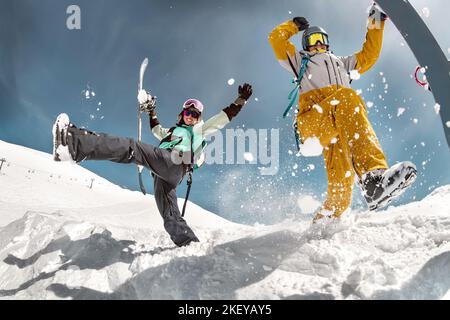 Happy couple of snowboarders are having fun and jumps. Winter holidays at ski resort Stock Photo