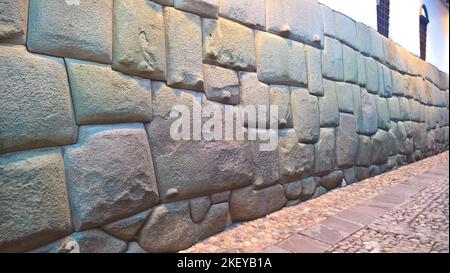 View to Twelve-angled stone aka Hatun Rumiyoc as a part of a wall of the palace of the Archbishop of Cuzco in Peru Stock Photo