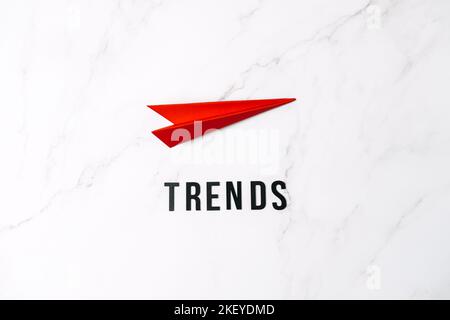 Global World Trends, Top New trends, forecasting. Word trends and red paper plane on red background. Stock Photo