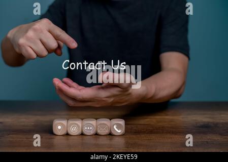 Hand holding and point on Contact Us for customer communication service with contact icon, E-mail, Phone number, Location, Social media group. Stock Photo