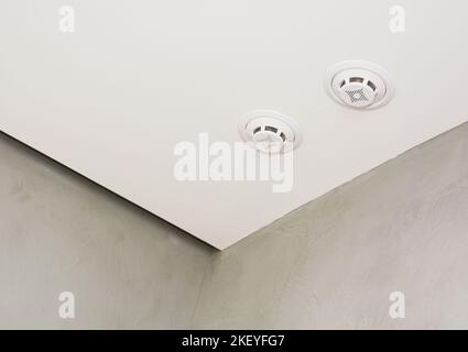 A close-up of a ceiling with a smoke alarm system, smoke detector indoor. Stock Photo