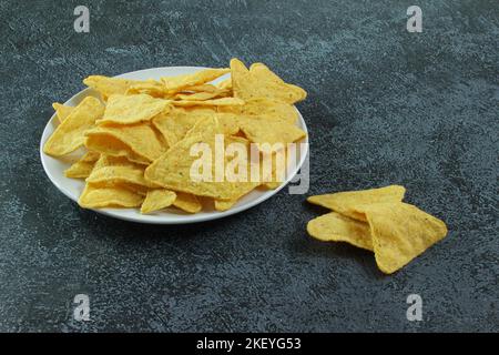 White plate with corn chips nachos on the concrete background. Mexican nachos. Stock Photo