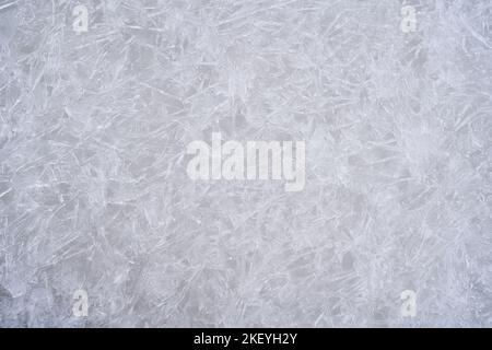 Fresh ice surface texture. Winter background with frozen snowflakes and snow mounds. Cold seasonal texture. Stock Photo