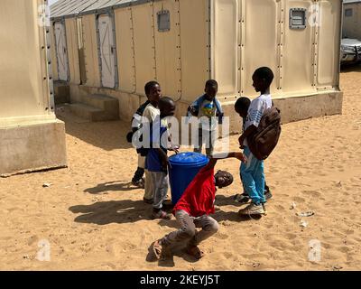 St. Louis, Senegal. 31st Oct, 2022. Children play while carrying a water barrel in the Diougoup tent city in St. Louis. (to dpa 'Dangerous proximity: The 'Venice of Africa' fights against floods') Credit: Lucia Weiß/dpa/Alamy Live News Stock Photo