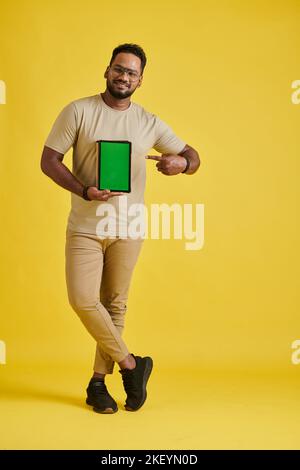 Happy programmer holding tablet computer with green screen, content production concept Stock Photo