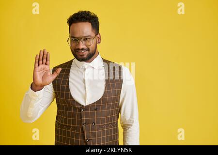 Portrait of cheerful man in glasses smiling and waving with hand Stock Photo