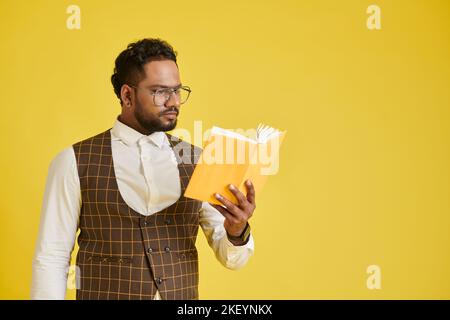 Studio portrait of concentrated man reading captivating book Stock Photo
