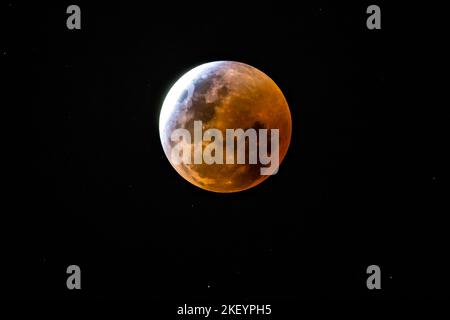 Nearing Total Eclipse as the Full Moon moves into the shadow of the Earth resulting in a total eclipse of the Moon and a Blood Moon caused by the ligh Stock Photo