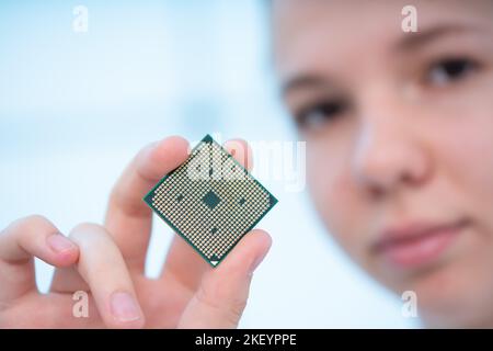 young woman holding in her hands the central processing unit for a laptop Stock Photo