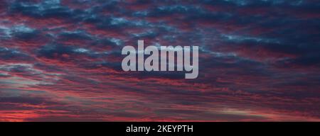 Beautiful purple and red sky at dusk. Beautiful sunset sky with pastel colors purple, sunset white clouds. Dramatic Sky, cloudscape. Stock Photo