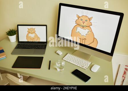 Workplace of graphic artist with computer monitor, laptop, smartphone, tablet with stylus, glass of water, green plant, keyboard and mouse Stock Photo