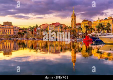 Scenic view of Christmas lights illuminated port of Sanary sur Mer in south of France reflected to Mediterranean sea during colorful sunset Stock Photo