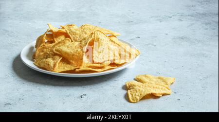 White plate with corn chips nachos on the concrete background. Mexican nachos. Stock Photo