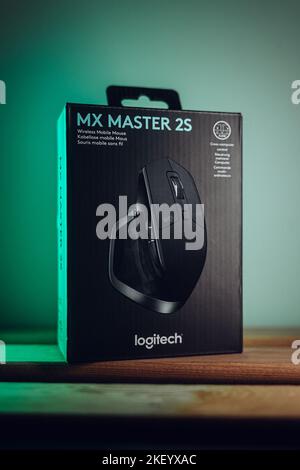 A vertical closeup of a black mouse from Logitech in the box, MX Master 2S on the green background Stock Photo