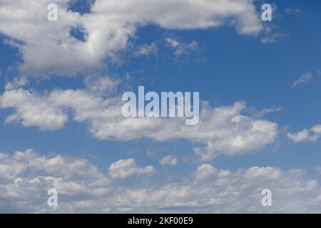 Summer midday pale blue sky with white fluffy lightest clouds torn evenly over it Stock Photo