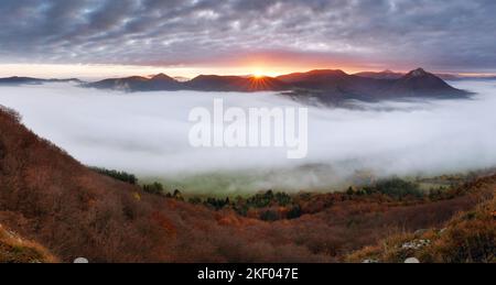 Simple shapes silhouette of mountains at sunset, warm colours in golden hour, panorama Stock Photo