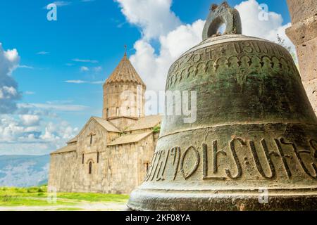Church of Saints Paul and Peter with bell in foreground with ancient Armenian letters, Tatev monastery, Syunik Province,  Armenia Stock Photo
