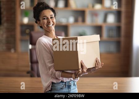 Happy young woman holding box parcel and smiling Stock Photo