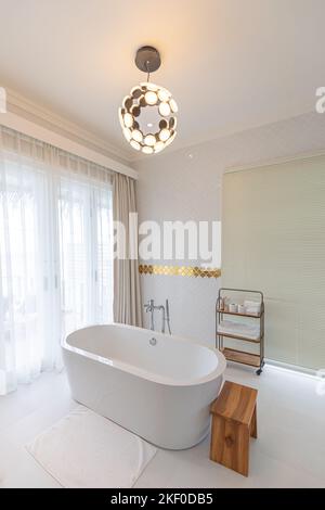 Luxury modern home bathroom interior with bright white cabinets, white marble decor walk in shower, free tub. Luxurious hotel resort interior, elegant Stock Photo