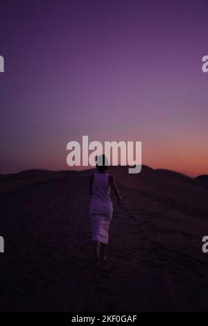 Woman in white walking barefoot on the beach Stock Photo - Alamy