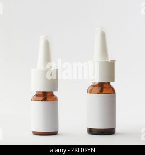 different size of brown glass nasal spray bottles mockup, medical moisturizer for flu and allergies, pharmaceutical aerosol with pump on a neutral gra Stock Photo