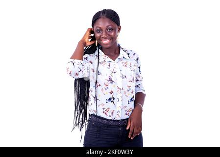a beautiful young woman wearing a long sleeve shirt standing on a white background looking at the camera smiling. Stock Photo