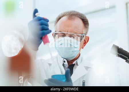 close up. researcher using an automatic dispenser in a medical laboratory. Stock Photo