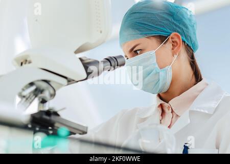 close up. female researcher looking through a microscope. Stock Photo