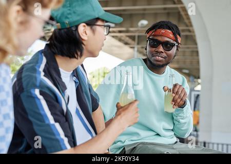 Young people hanging out together in urban setting and enjoying drinks Stock Photo