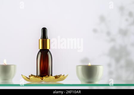 Amber glass dropper bottle with serum, essential oil or fruit peeling on a glass shelf on blue background with copy space. SPA natural organic cosmeti Stock Photo